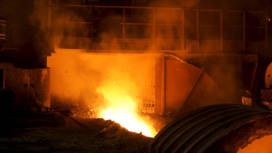 流动的液态金属和飞溅的火花的高炉。库存镜头。工厂铁水生产的特写，重工业概念。