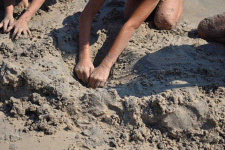 孩子们在堆沙子。孩子们在海滩上玩耍。