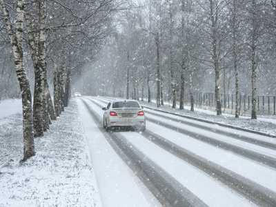 冬季交通车辆。降雪中的冬季乡村公路
