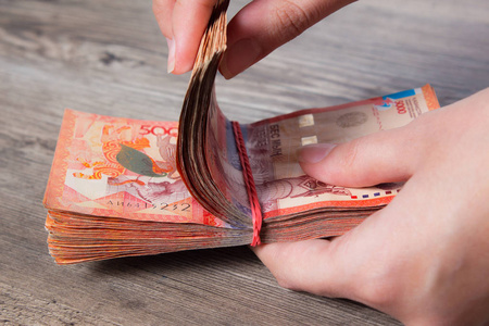 通货膨胀邮票手拿着一沓带着松紧带的钱.腾格kzt.