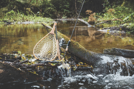 一条风景如画的森林河流背景上的渔具。
