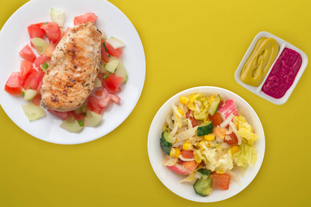 Grilled chicken breast with tomato salad, cucumbers and onions. 