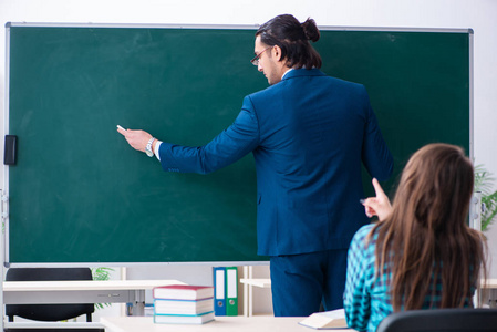 年轻帅气的老师和教室里的女学生