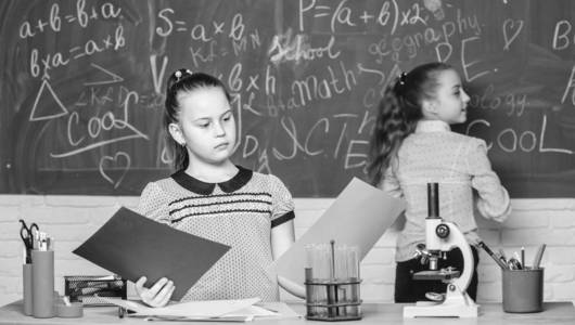 学校课程。女孩在学校学化学。显微镜试管化学反应。小学生们在黑板前。迷人的科学。教育实验。正规教育学校。回到学校