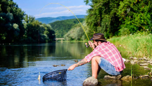 对灵魂的爱好。与自然合一。渔夫使用鱼竿捕鱼技术。捕鱼的人。钓鱼的家伙。成功的飞钓。河边的人一边钓鱼一边享受宁静的田园风光