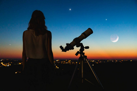 Astronomer with a telescope watching at the stars and Moon with 