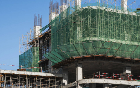 在建建筑和施工现场。蓝天下的建筑工地。未完工建筑的金属结构多仓库建筑的施工。