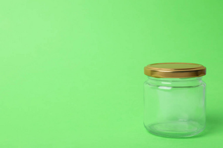 浅绿色背景上的封闭式空玻璃罐，用于放置文本