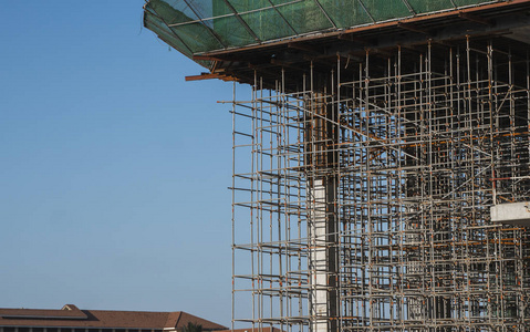 在建建筑和施工现场。蓝天下的建筑工地。未完工建筑的金属结构多仓库建筑的施工。