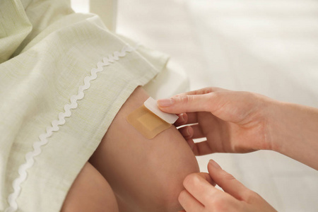 妈妈在屋里给女儿的腿贴膏药,clo照片