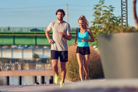 Modern woman and man jogging  exercising in urban surroundings 