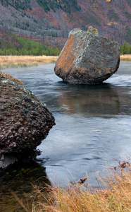 巨大的岩石巨石坐落在流动的河流中