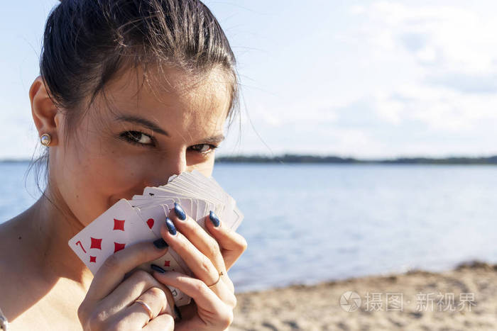 年轻的高加索女孩手里拿着扑克牌