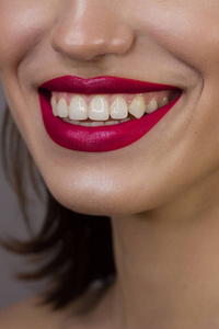 美丽性感的嘴唇充满粉红唇彩.光滑的牙齿和干净的深色皮肤.口红照片