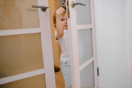 恶作剧的小男孩可爱可爱的小男孩在家关门照片