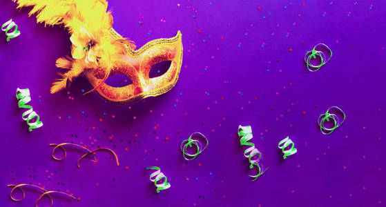 金色嘉年华面具，紫色背景，闪闪发光。狂欢节概念。复制空间