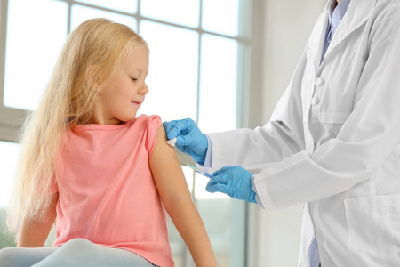 医生在诊所给小女孩接种疫苗