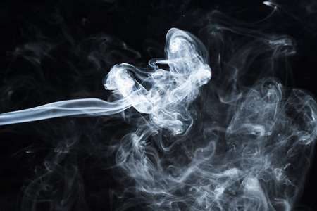 一缕烟在黑暗背景下的照片照片