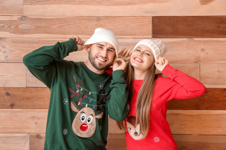 木质背景上穿着圣诞服装的幸福夫妇肖像