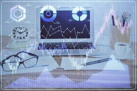 以电脑为背景的彩色财务图表和表格。多重曝光。国际市场的概念。