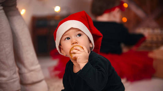 圣诞概念一个小男孩把圣诞球放进嘴里