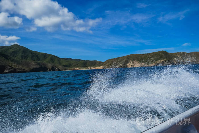 这张照片是从一艘以大海和山脉为背景的船上拍摄的