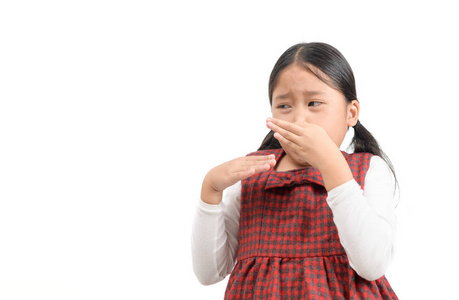 可爱的亚洲女孩用手指捏鼻子恶心的表情照片