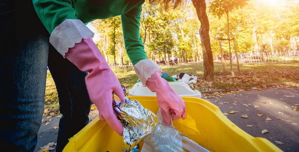 志愿者女孩在公园的街道上分类垃圾。回收的概念。零浪费理念。自然