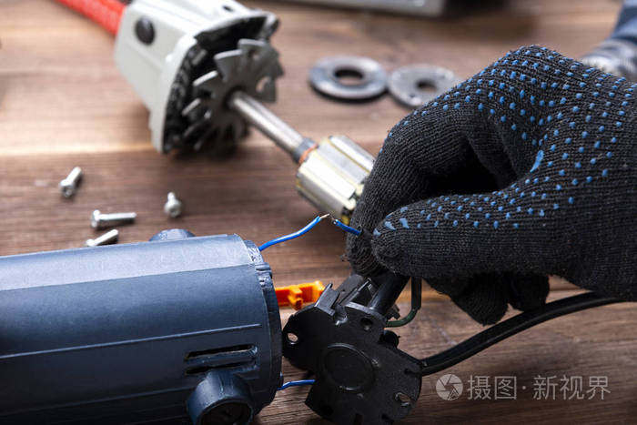 主人修理一个坏了的电器钻头木桌上的切割机电动工具修理厂