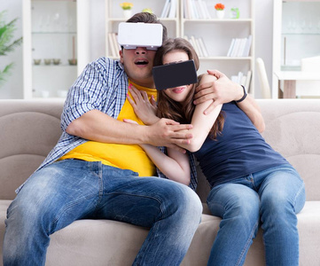 戴着虚拟现实眼镜玩游戏的年轻家庭