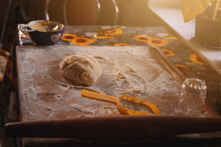 在家里做饺子，面团和面粉在木板上包饺子。