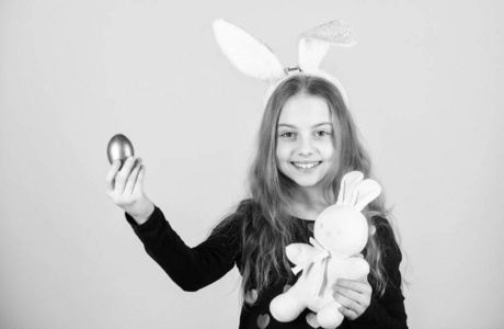 迎接春节假期。复活节彩蛋是节日的一部分。小女孩复活节兔子配件举行染色彩蛋。复活节兔子的起源。复活节的象征和传统。带着柔软玩具的顽