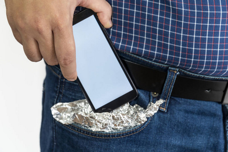 把智能手机放在口袋里，口袋里盖着箔纸的人