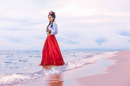 beautiful young stylish boho woman walking on the beach 