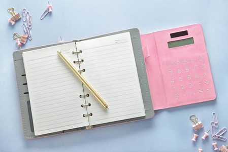 带计算器和文具的时尚笔记本放在白色桌子上