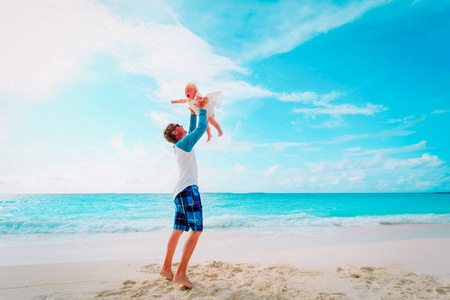 爸爸和可爱的小女儿在沙滩上玩耍