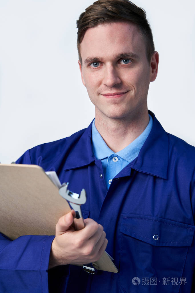 男工程师带着剪贴板和扳手的工作室肖像