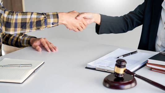 lawyer or attorneys shaking hand with client after consultation 