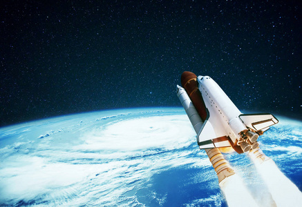 宇宙飞船与一颗蓝色的行星在星空中飞翔照片