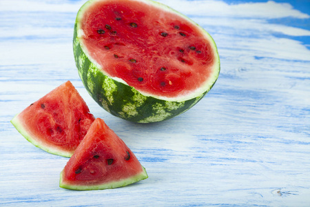 Pieces of watermelon on a blue wooden table. 