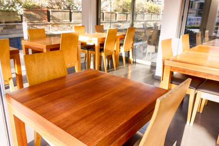 Empty wooden chairs and tables in street cafe.