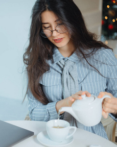 年轻漂亮的女人坐在咖啡馆里喝着茶