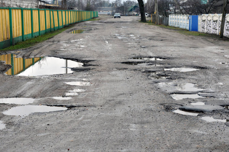 沥青上有洞,开车有危险,沥青差,道路危险,沥青坑坑洼洼.照片