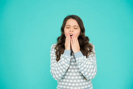 困女孩打哈欠蓝色背景.一脸困倦的小孩.清晨或傍晚.时尚与美丽.