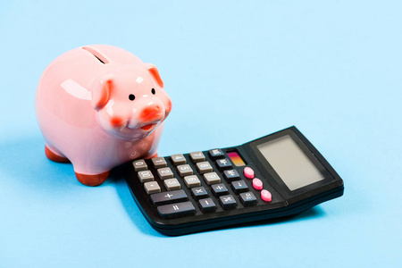 存钱罐是储蓄的象征。会计服务。会计业务。会计软件。财务和投资。小猪银行粉红猪和计算器。会计和家庭预算
