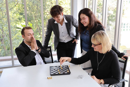 白种商人和女商人在办公室会议室下棋，这意味着商业计划和成功战略团队合作和伙伴概念
