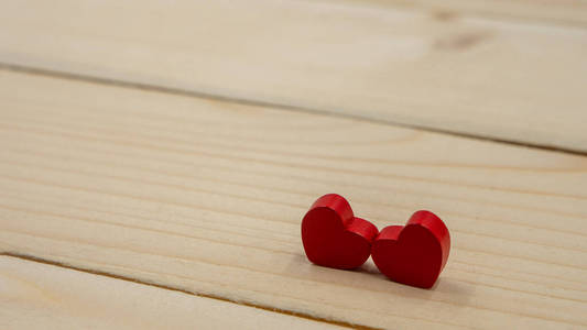 两颗红心放在一张木桌上。