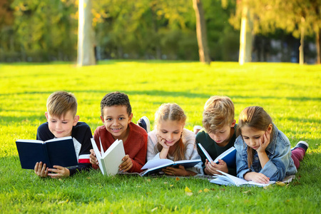 可爱的小孩子在公园里看书