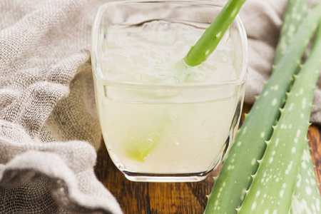 新鲜芦荟汁和叶子的玻璃器皿照片