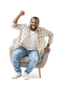 Emotional AfricanAmerican man watching TV while sitting in armc